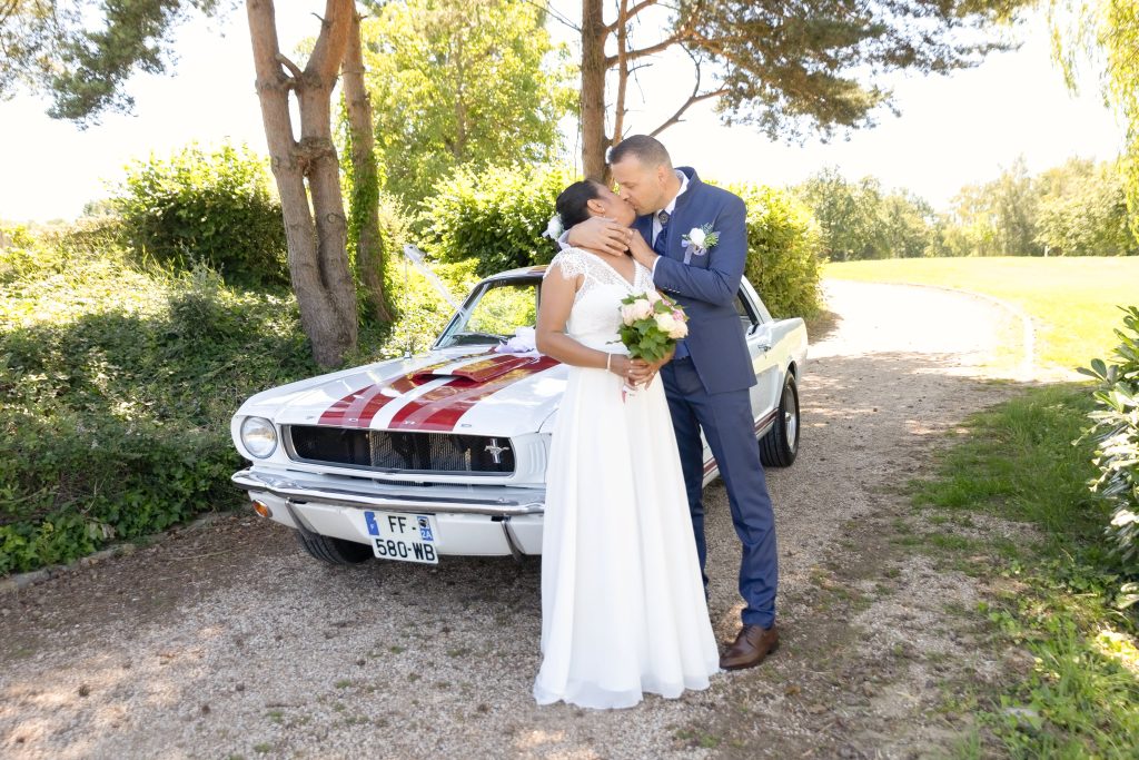 Couple de mariés devant une Ford Mustang – photographe mariage Seine-et-Marne floGé